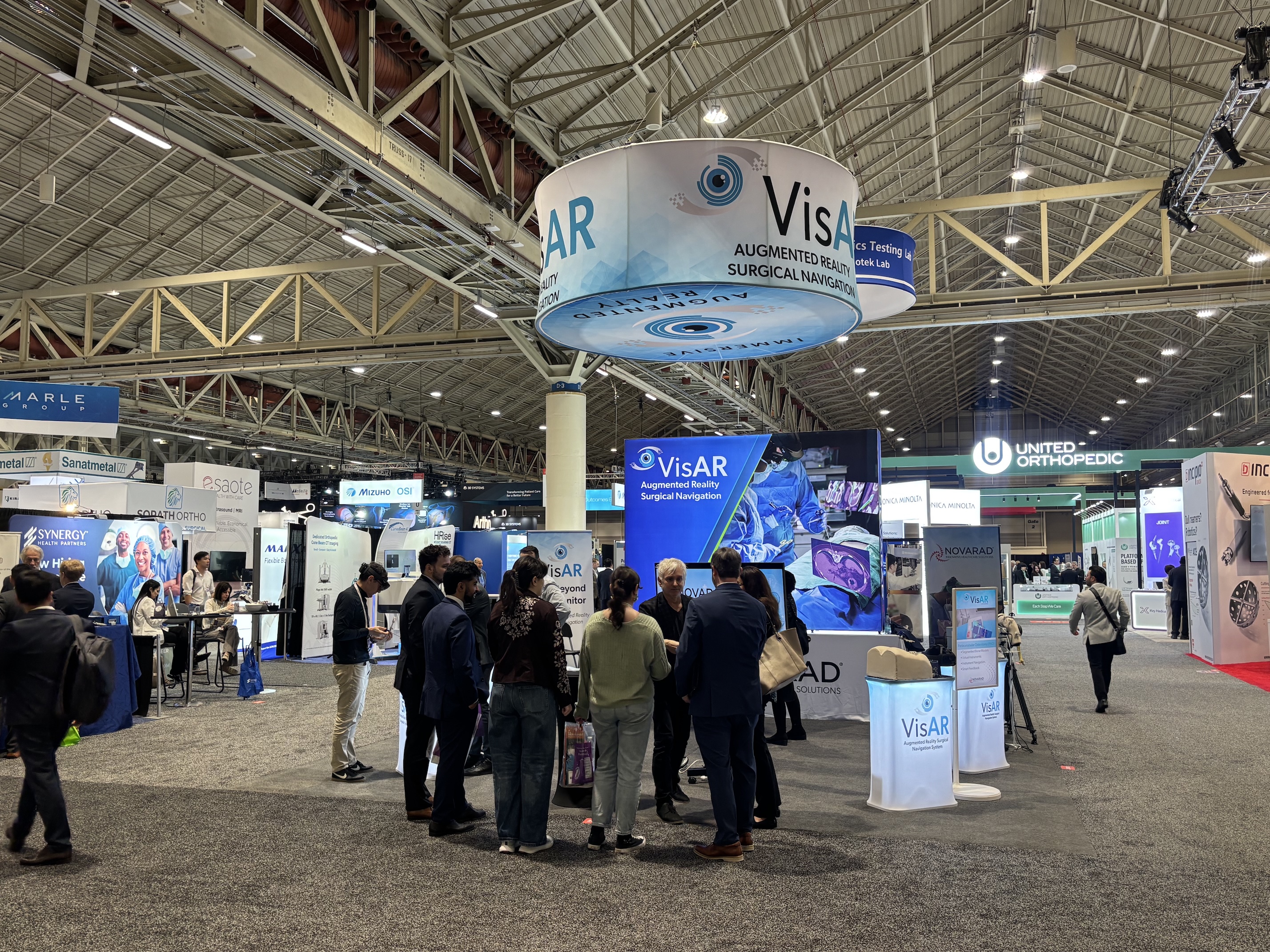 Novarad VisAR augmented reality surgical navigation booth at the AAOS orthopedic conference with surgeons and attendees watching live demonstrations.
